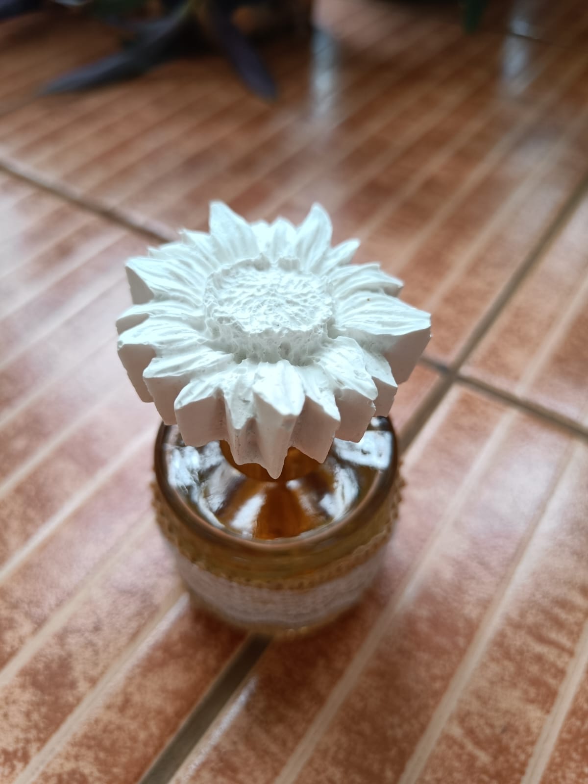 White sunflower aroma stone diffuser on a decorated glass bottle