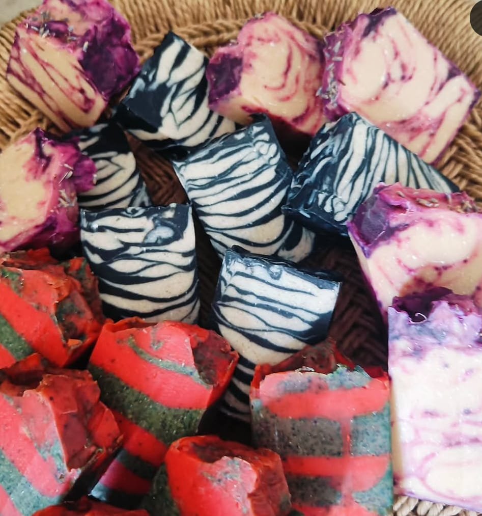 A basket of assorted handmade cold process soaps — zebra swirl, lavender purple and watermelon red-and-green bars — from the 24-Hr Faster Curing Cold Process Soap Workshop